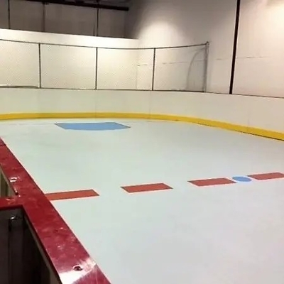 L'individu d'UHMWPE lubrifiant la glace artificielle d'hockey extérieur couvre de tuiles la piste de patinage